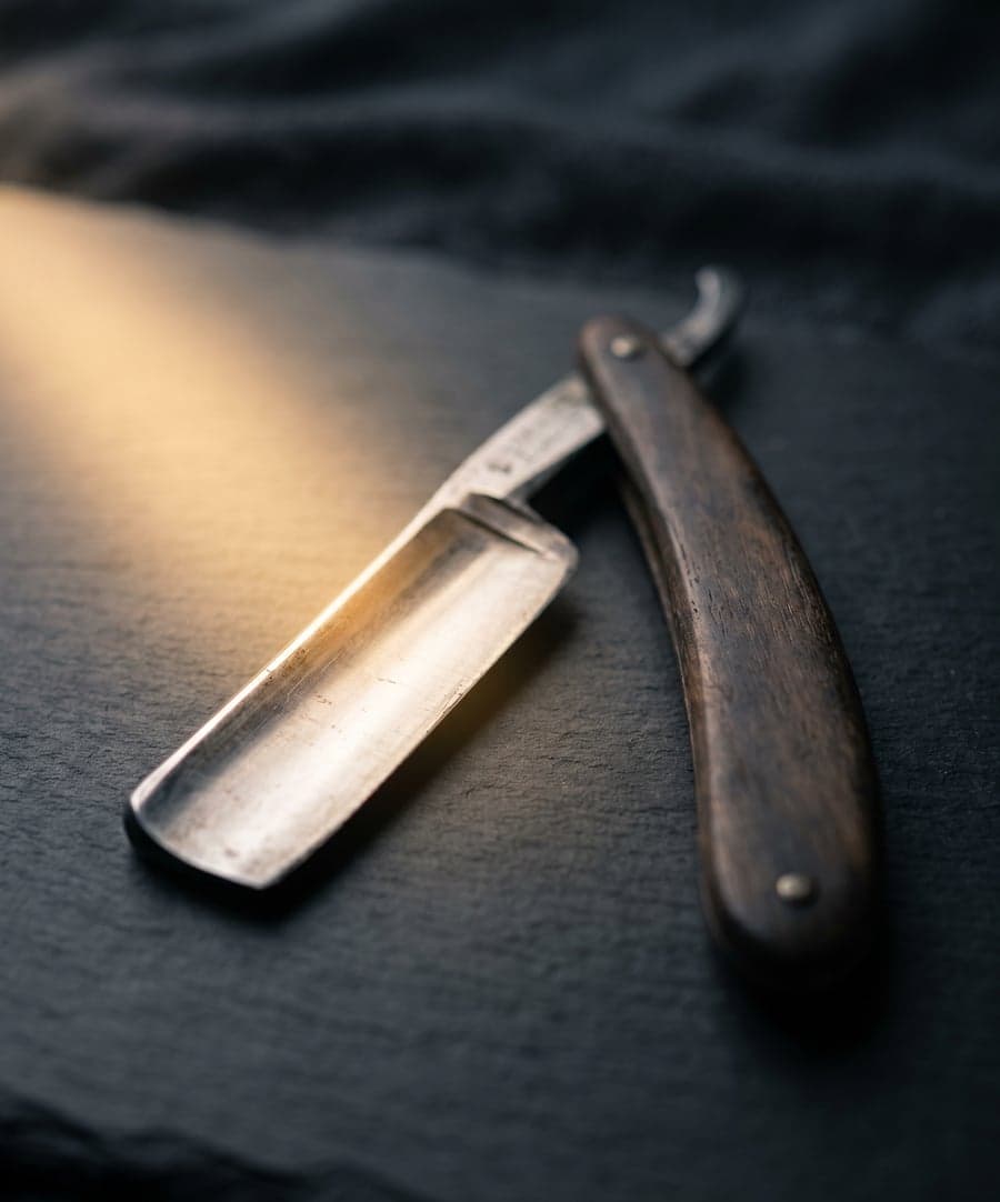Vintage straight razor, gold light along the blade edge